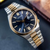 Citizen automatic wristwatch with blue face and gold accents.