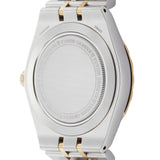 Back of a silver and gold watch with text.