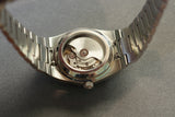 Back of a silver wristwatch showing the inner workings.